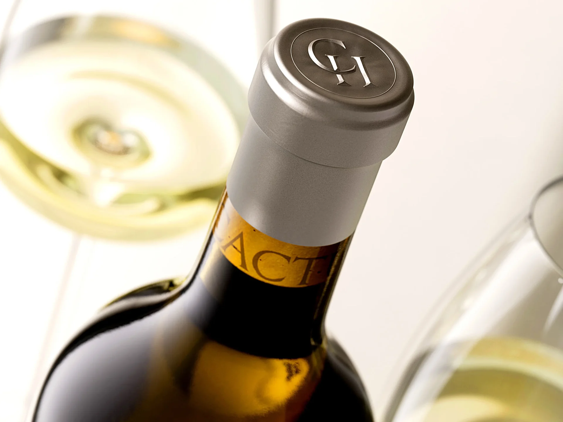Top view of custom 38mm polylaminate wine capsule with silver CH monogram embossing — luxury wine packaging by Dagaprint